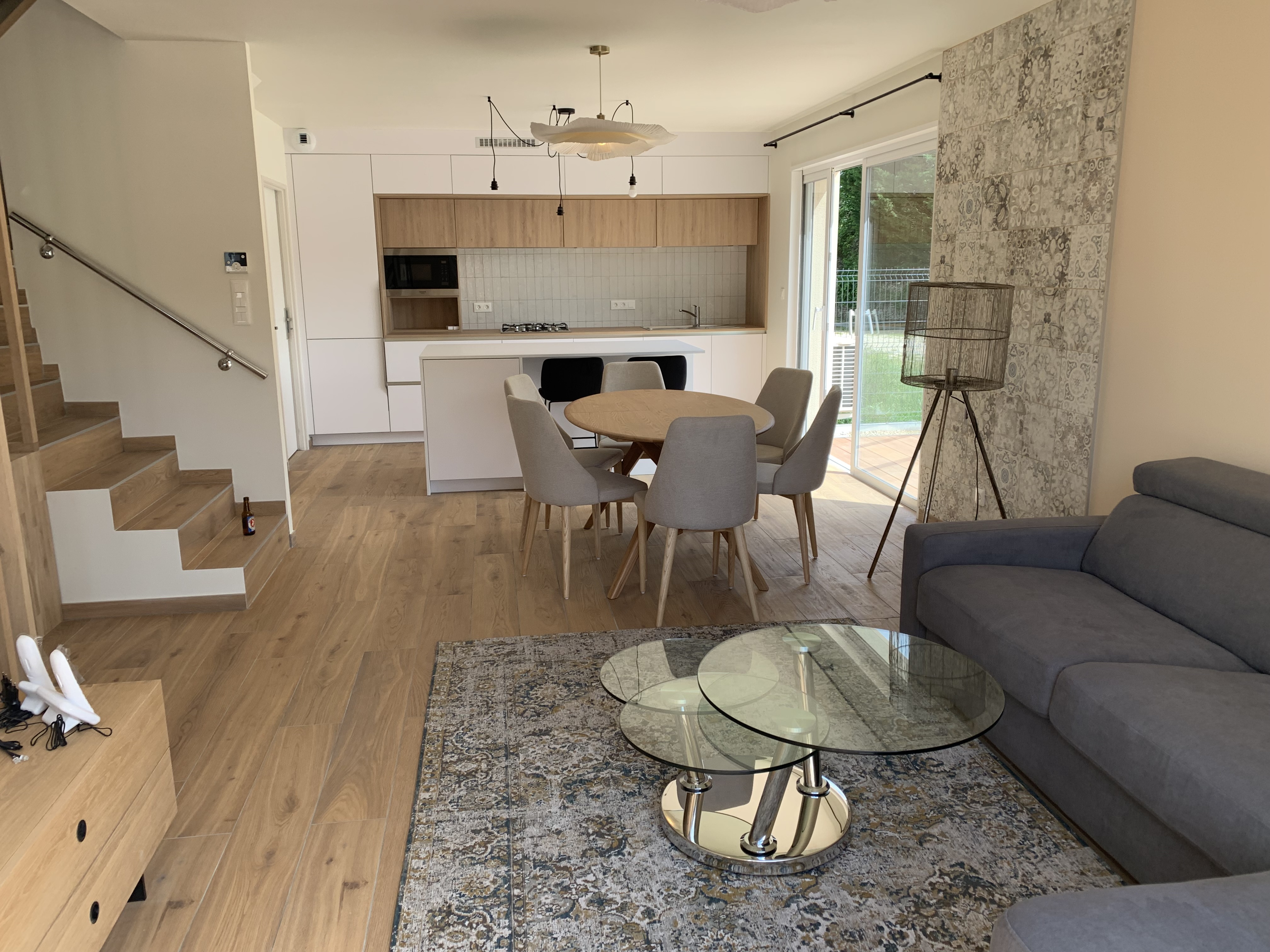 Cuisine ouverte et séjour rénovés avec parquet et escalier en bois